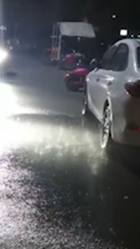 男生单手遮雨骑车撞路边汽车后逃逸，一场意外的雨与不负责任的行为